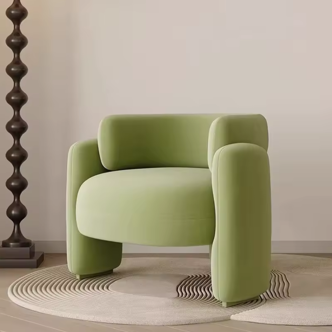 Green armchair in a minimalistic room with a lamp and rug.