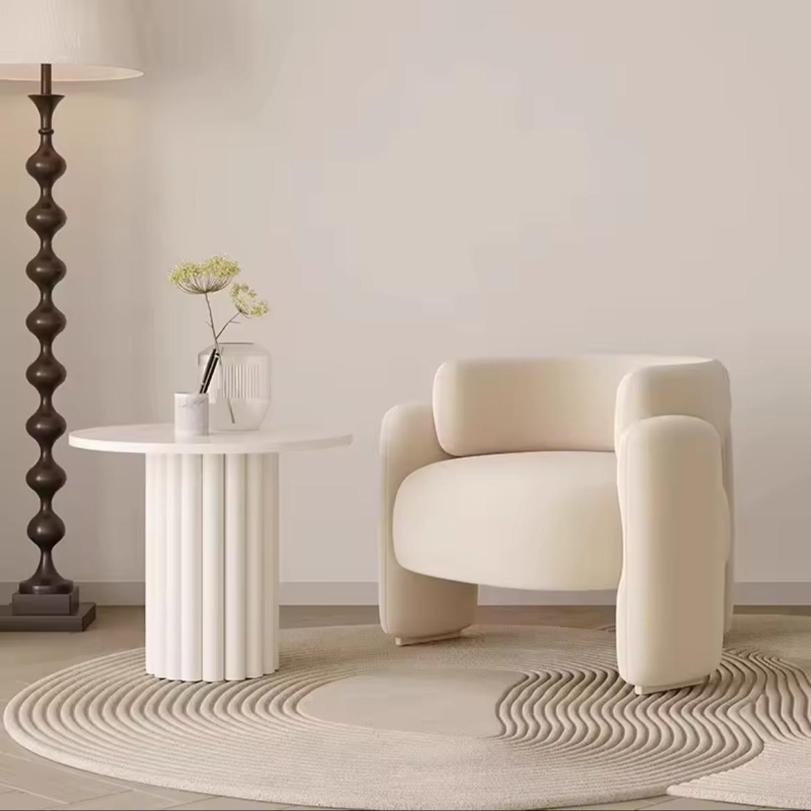 Beige armchair in a minimalistic room with a side table and lamp.