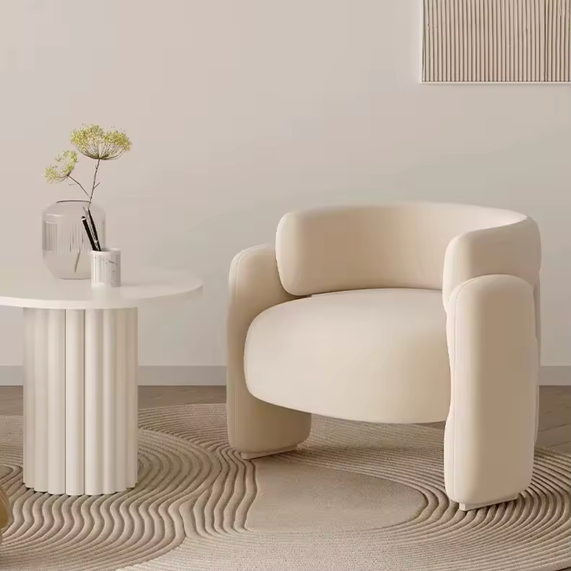 Modern beige armchair in a minimalistic room with a white wall and small round table.