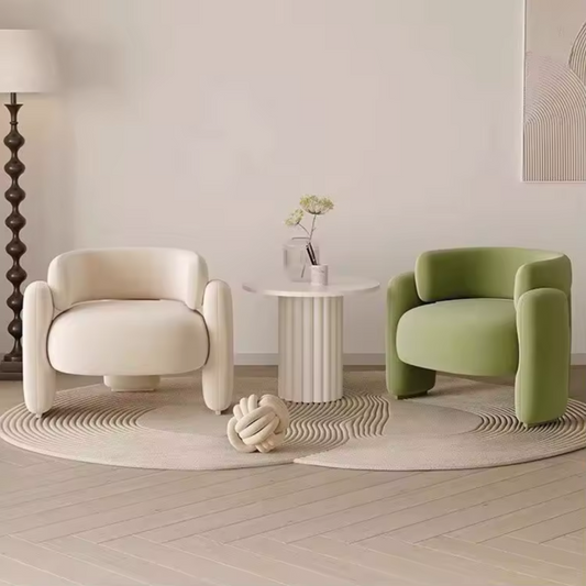 Two armchairs, one white and one green, in a modern living room setting.