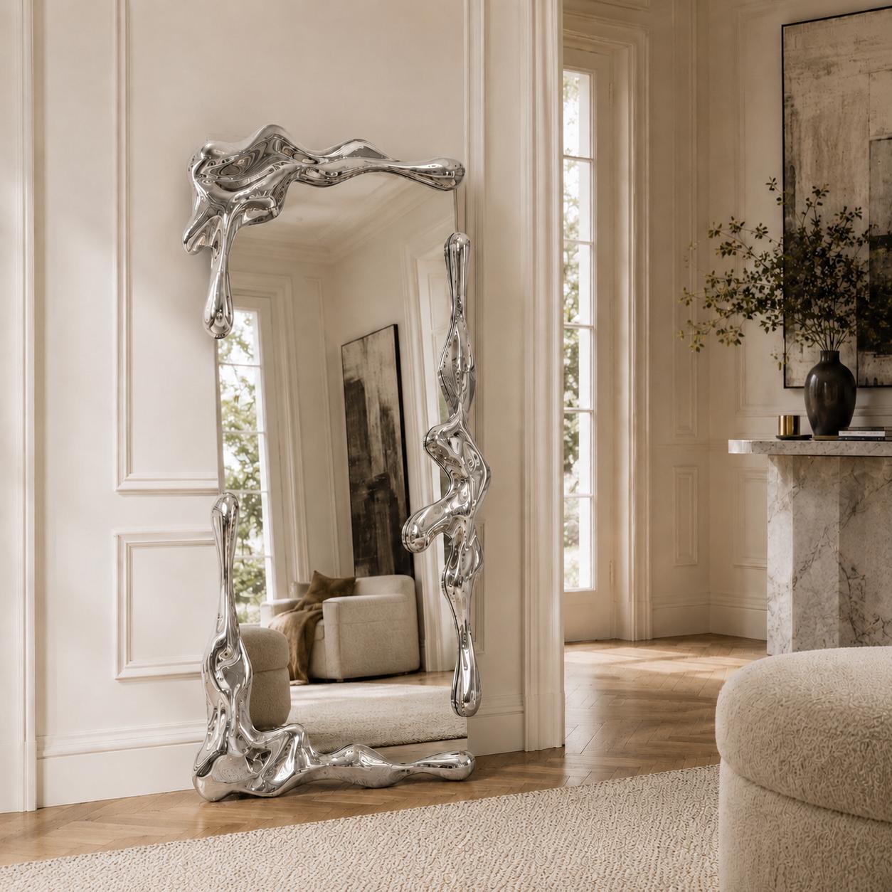 Sculptural full length liquid mirror with an organically shaped polished silver frame in a luxury contemporary interior.