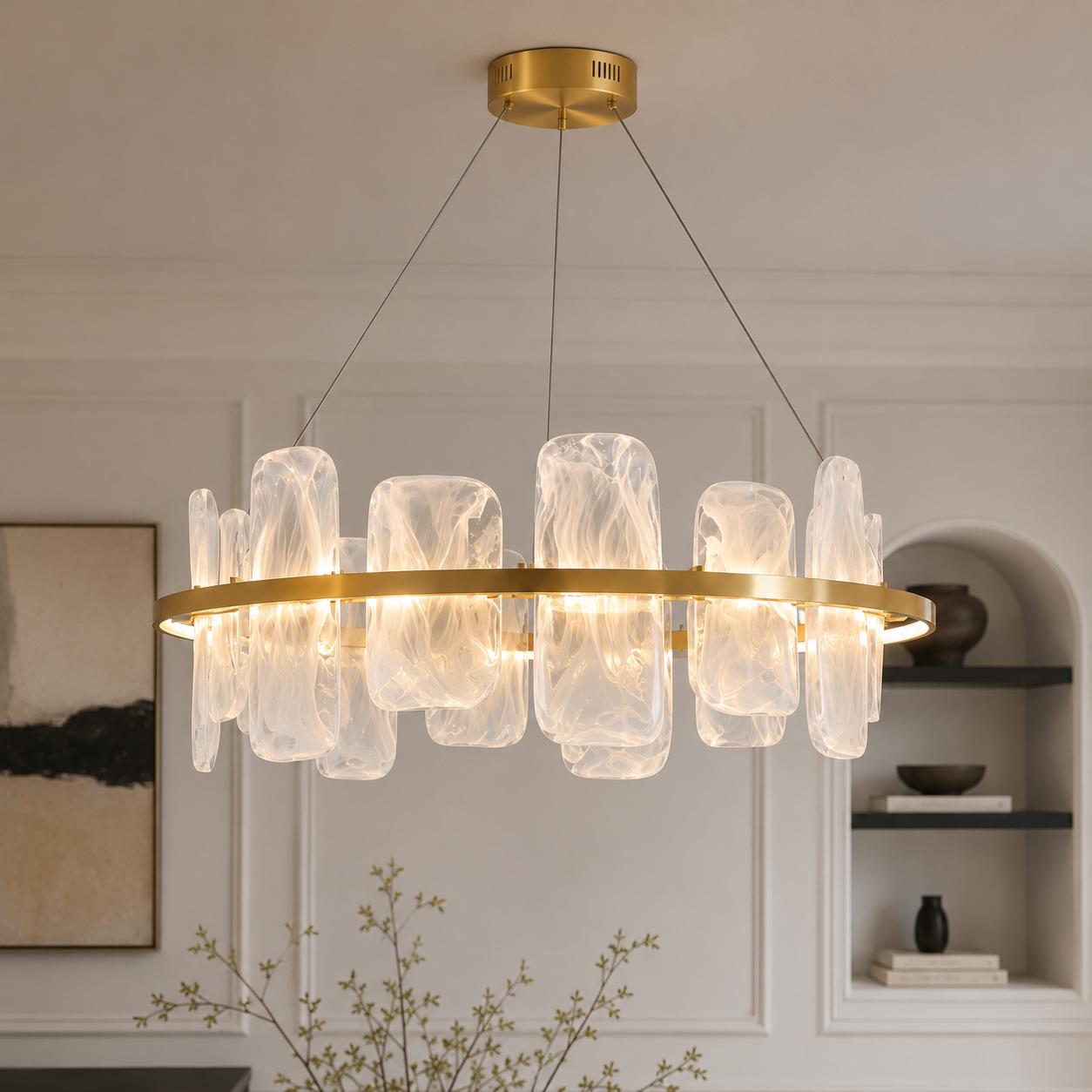 Contemporary brushed gold circular chandelier with smoked pattern glass shades suspended above a luxury dining space.
