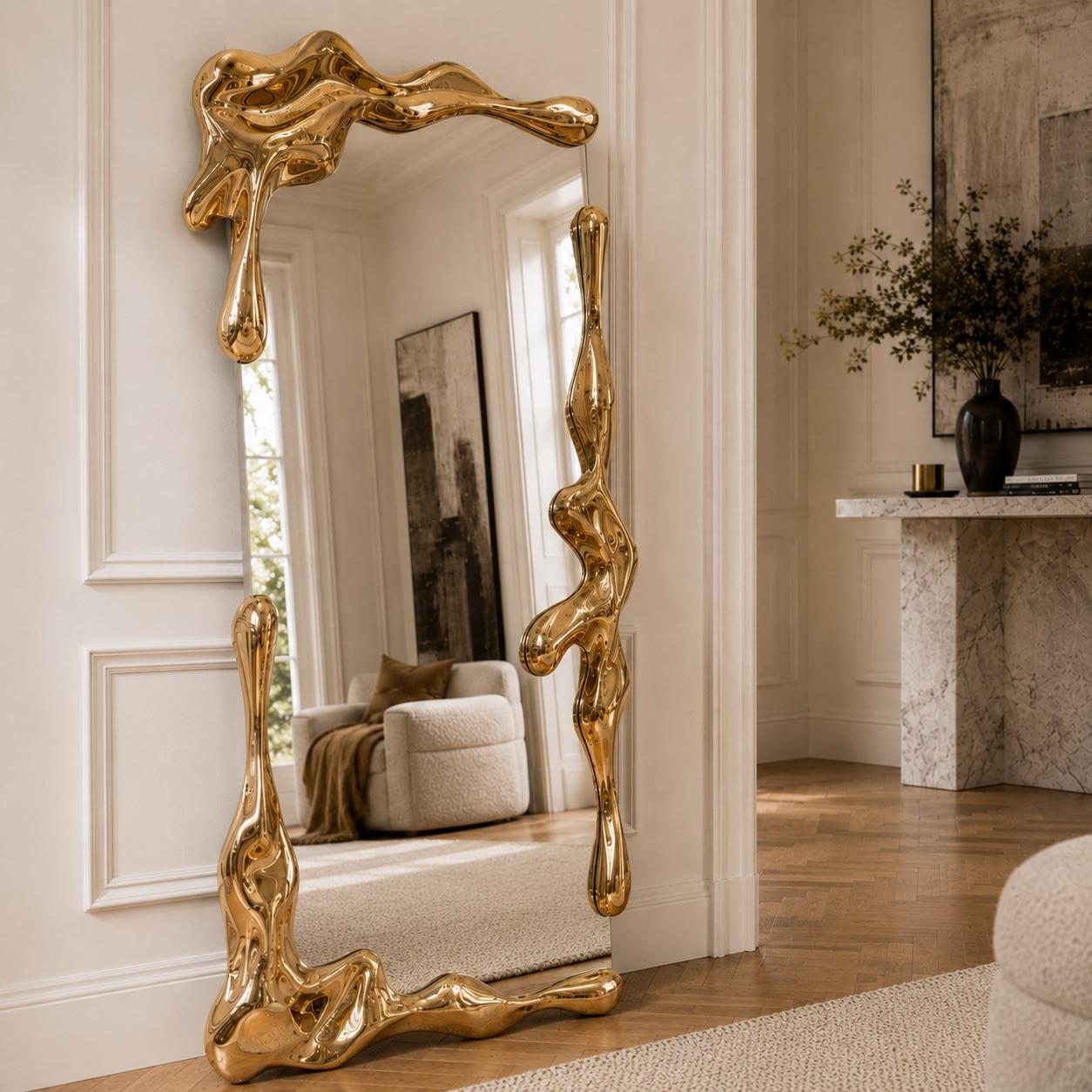 Sculptural full length liquid mirror with an organically shaped polished gold frame in a luxury contemporary interior.
