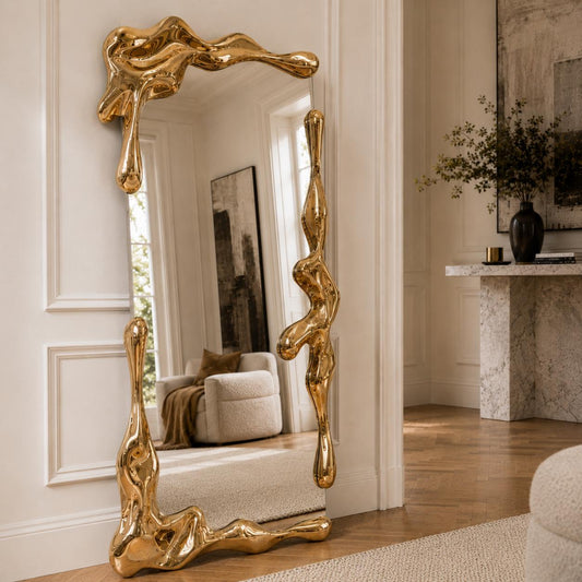 Sculptural full length liquid mirror with an organically shaped polished gold frame in a luxury contemporary interior.