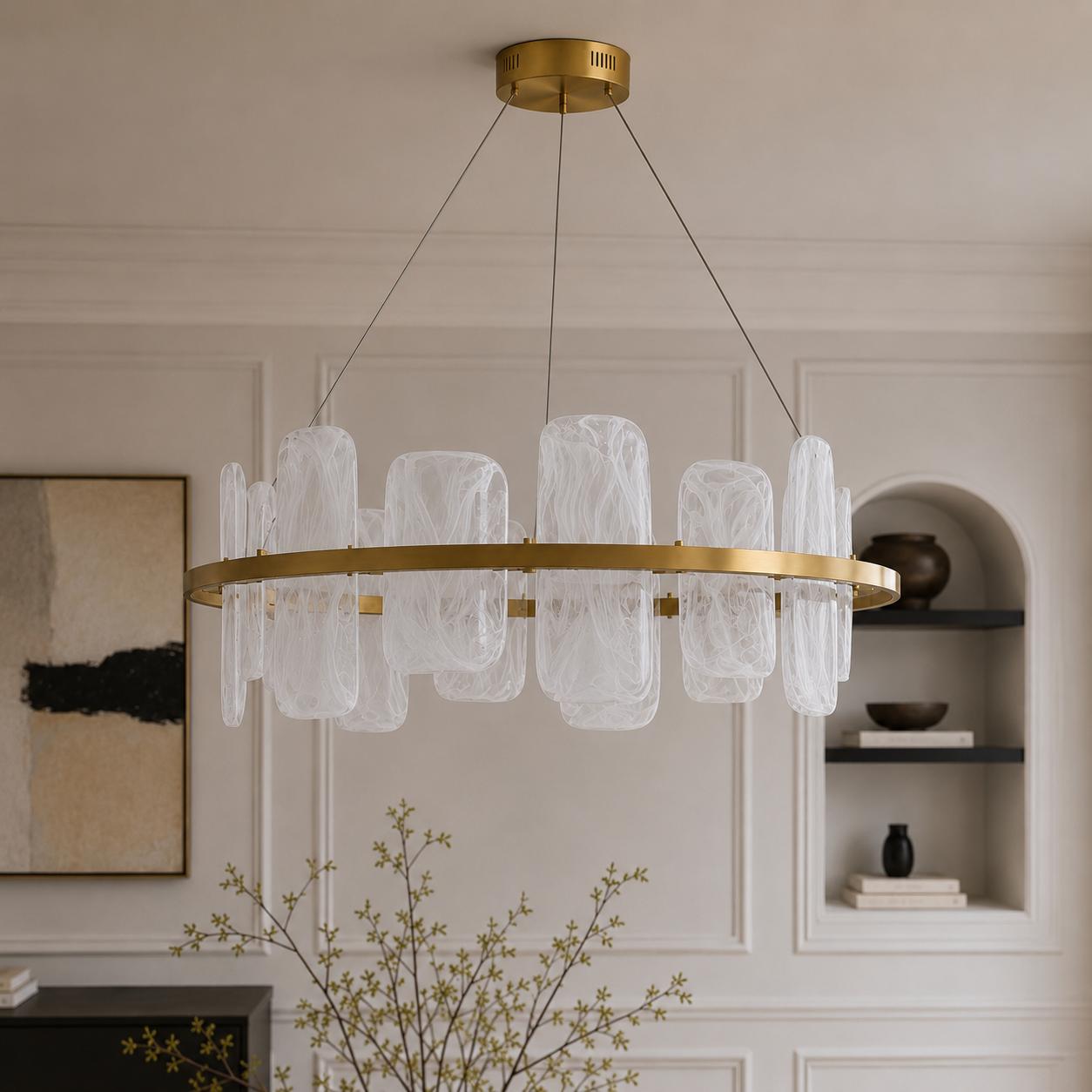 Contemporary brushed gold circular chandelier with smoked pattern glass shades suspended above a luxury dining space.