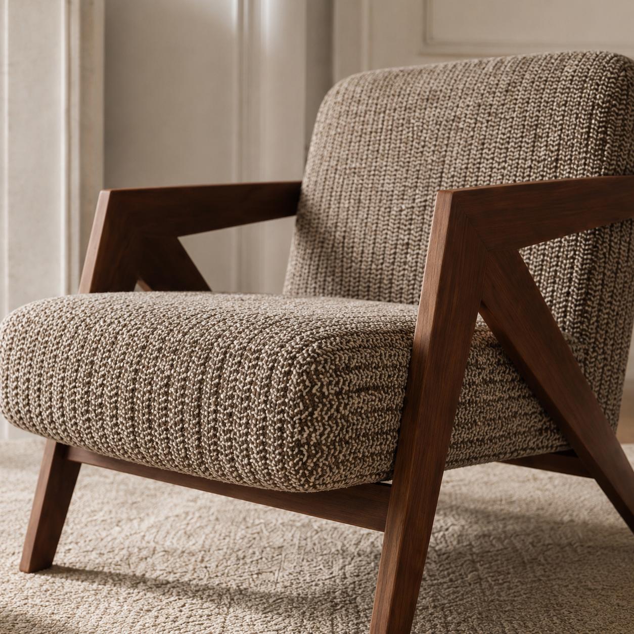 Contemporary armchair with premium woven fabric upholstery and a walnut finished wood frame in a luxury living room.