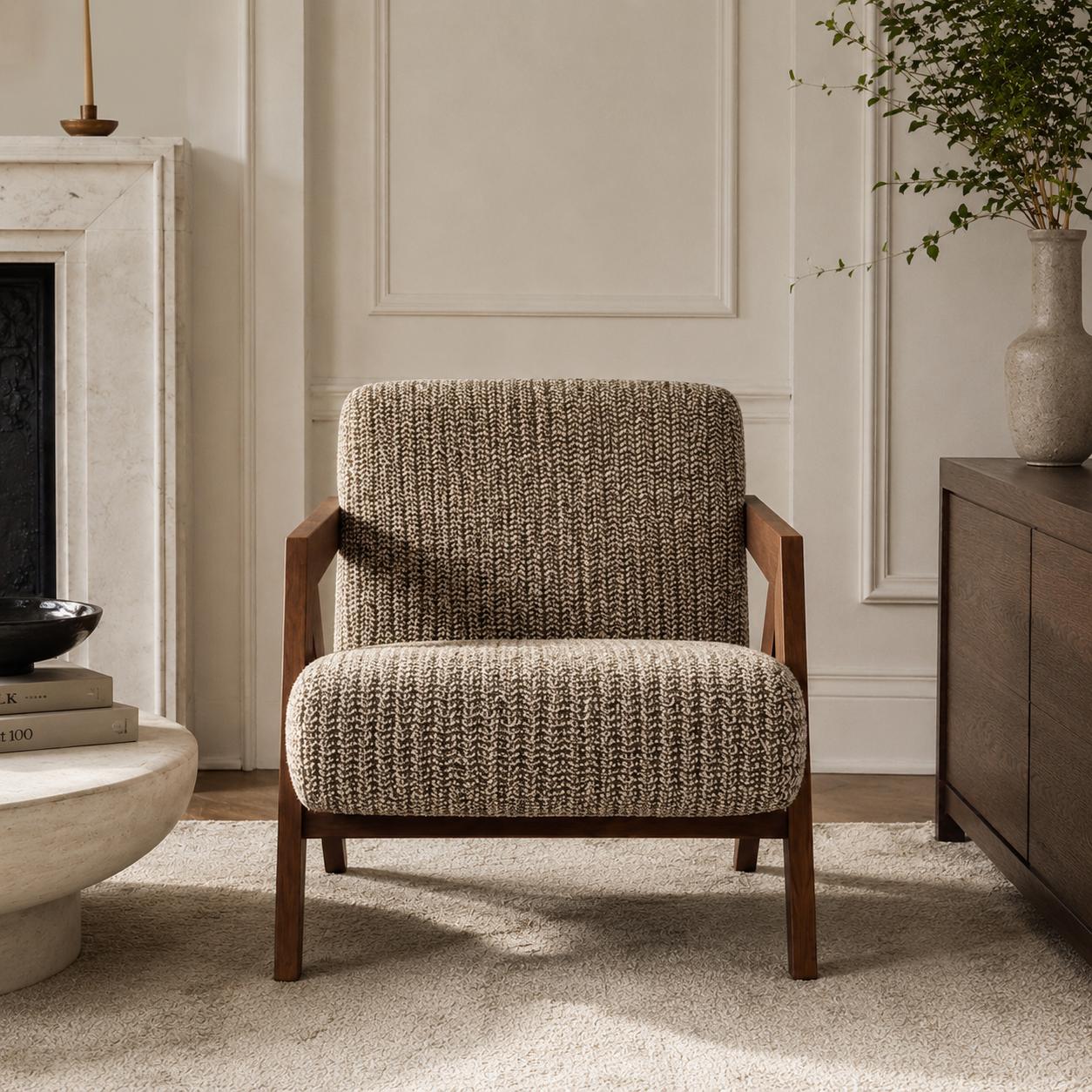 Contemporary armchair with premium woven fabric upholstery and a walnut finished wood frame in a luxury living room.