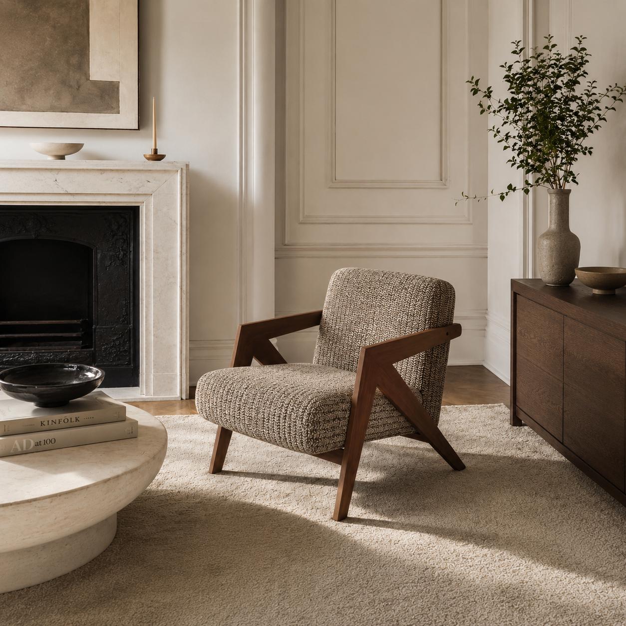 Contemporary armchair with premium woven fabric upholstery and a walnut finished wood frame in a luxury living room.