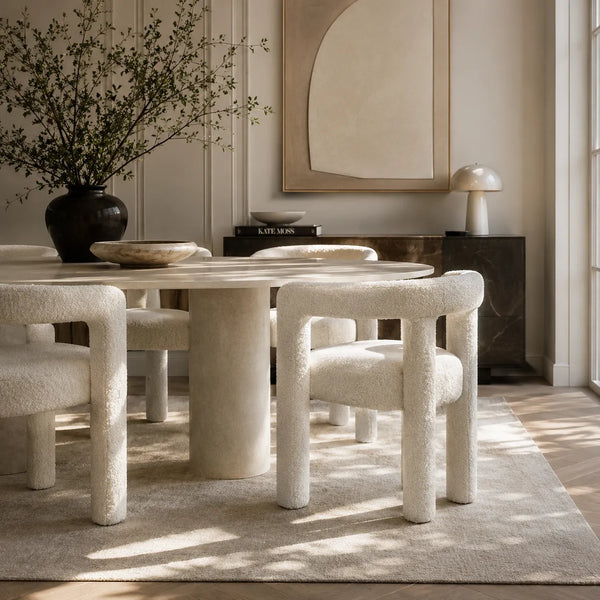 Dining room with marble table and textured chairs on a rug