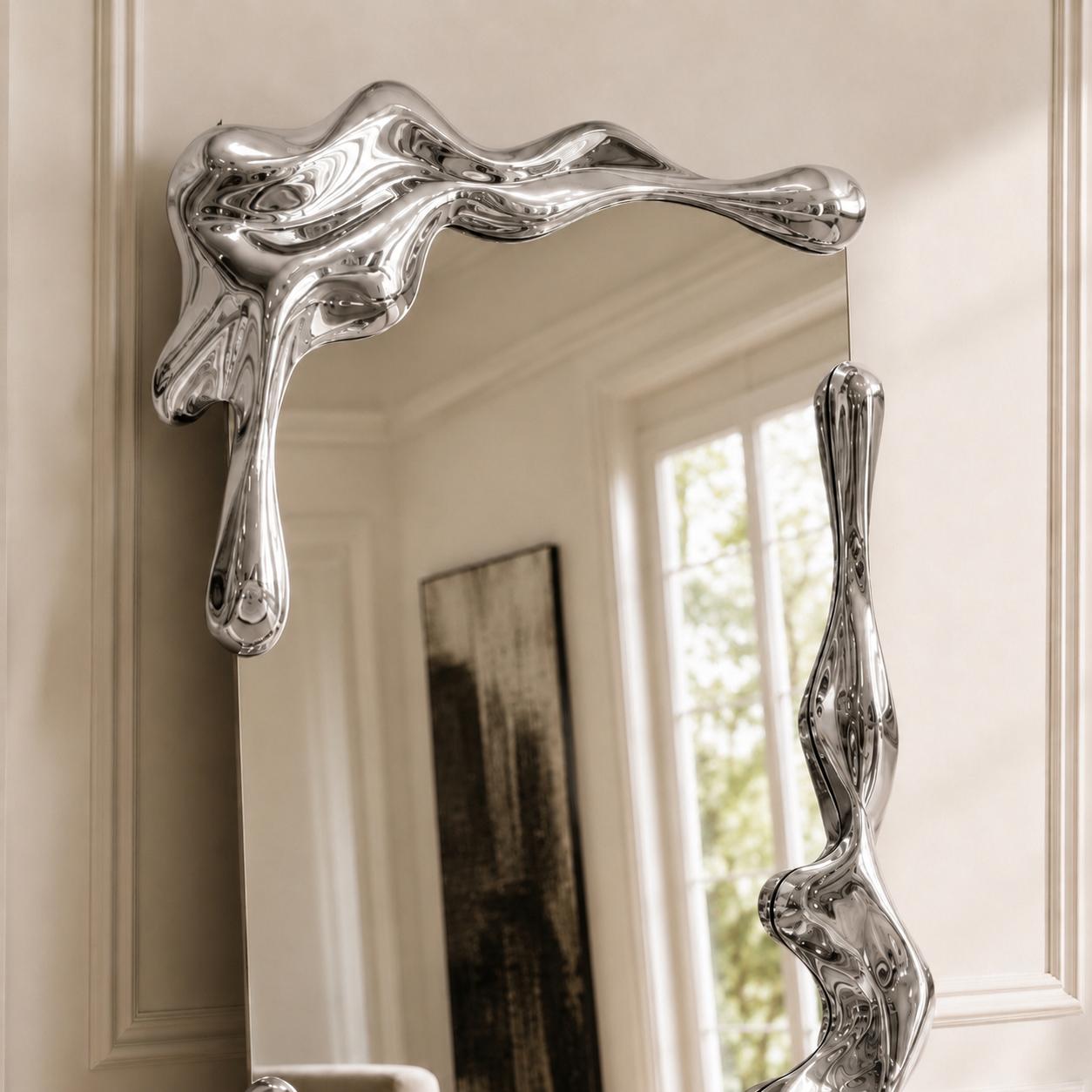 Sculptural full length liquid mirror with an organically shaped polished silver frame in a luxury contemporary interior.
